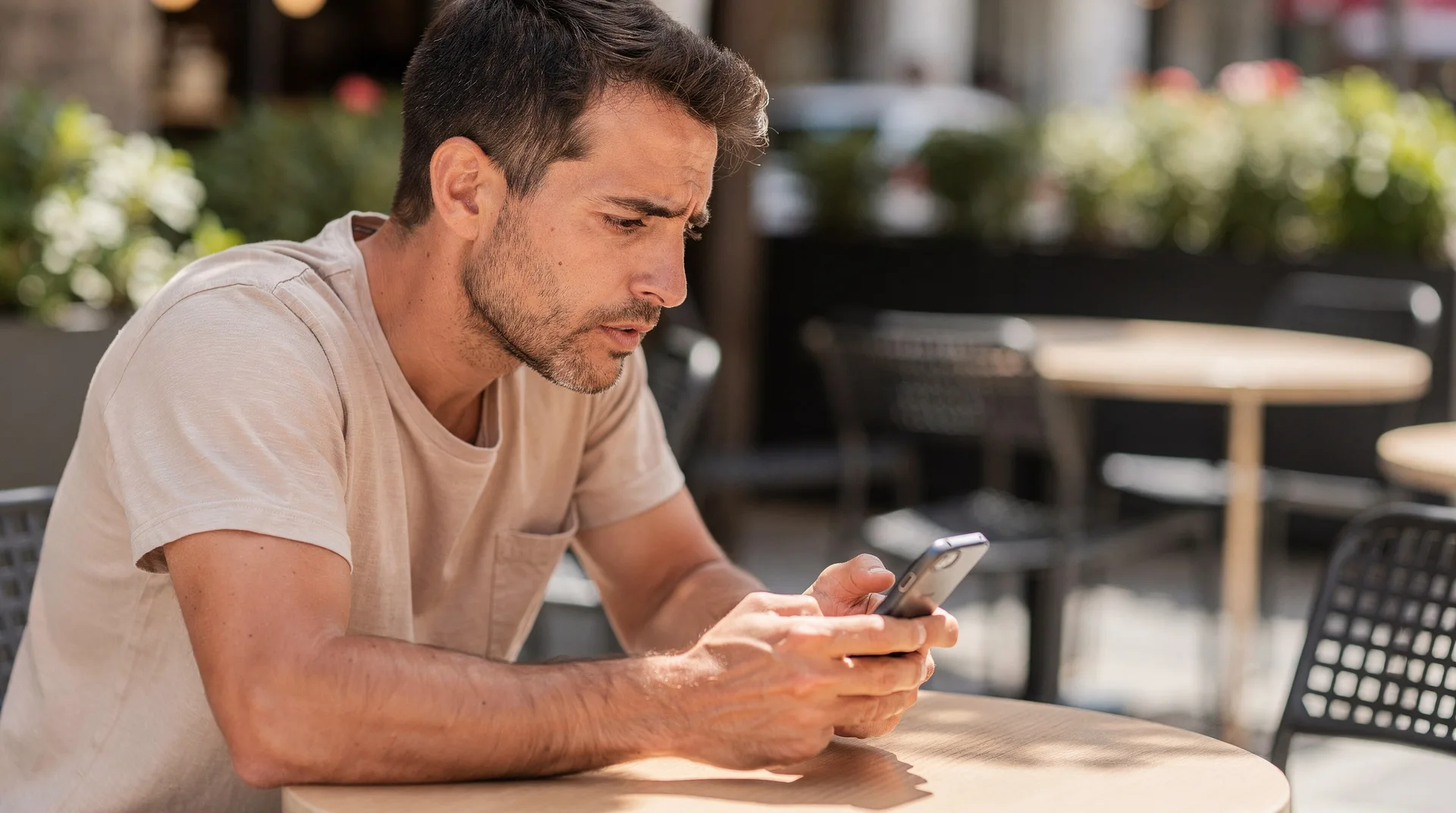 Persona mirando su móvil con gesto de preocupación tras descubrir una app de préstamos fraudulenta en España